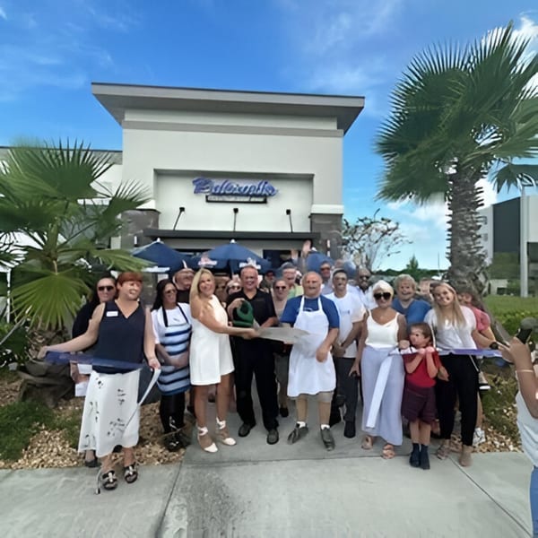 Pulcinella Pizza and Italian Market staff and community gather for a ribbon-cutting ceremony outside the restaurant.
